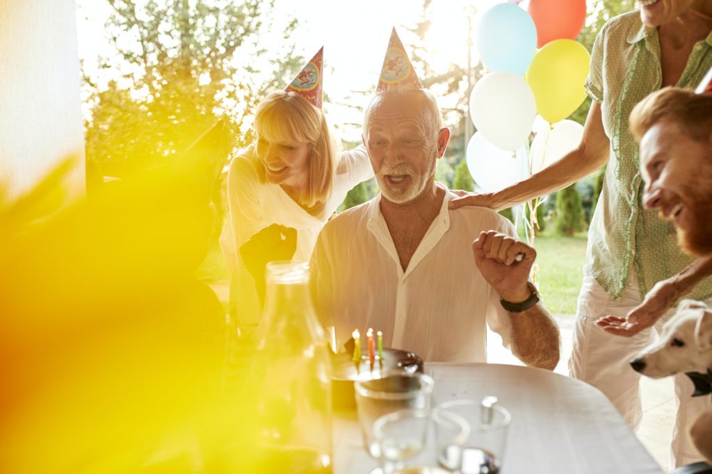 Happy family learning the Parts of Medicare at a garden birthday party